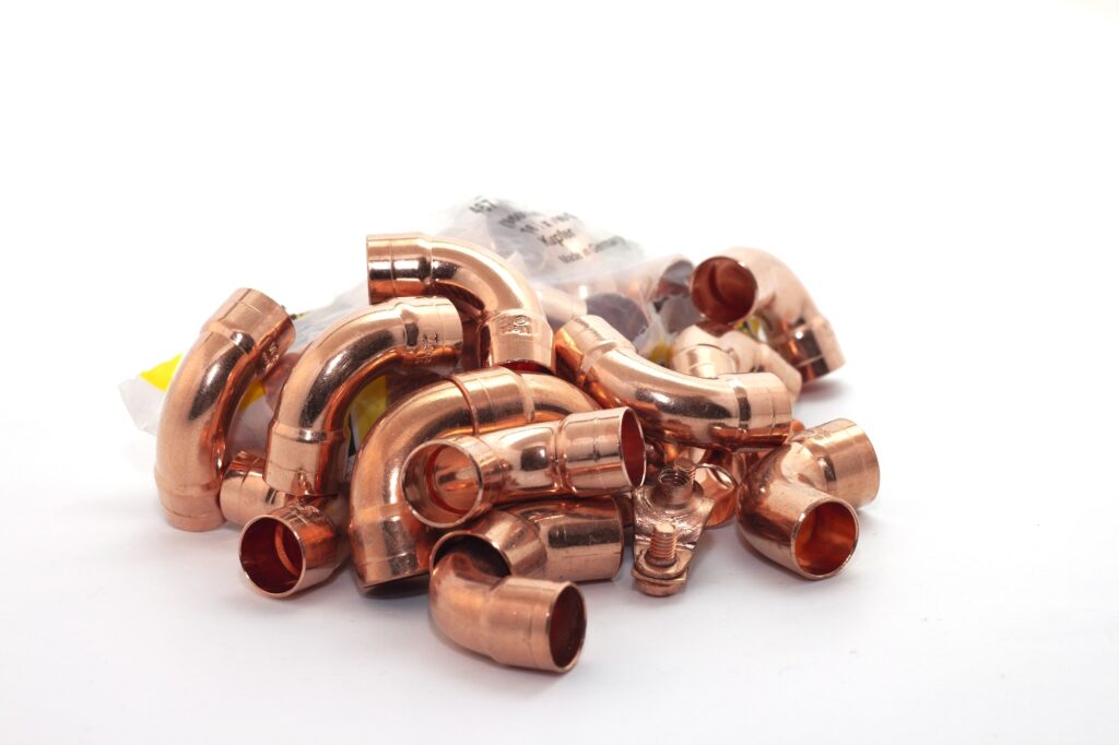 Closeup shot of the curved copper fittings for plumbing isolated on white background