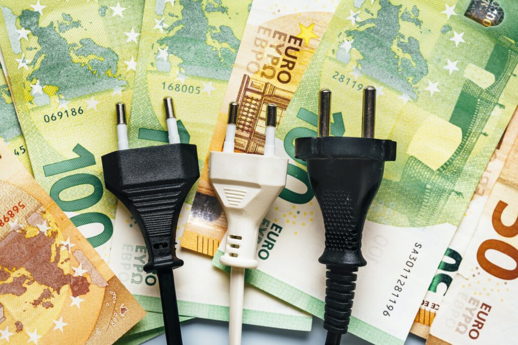 Electrical plug next to euro banknotes showing the financial inflation problem and energy crisis in