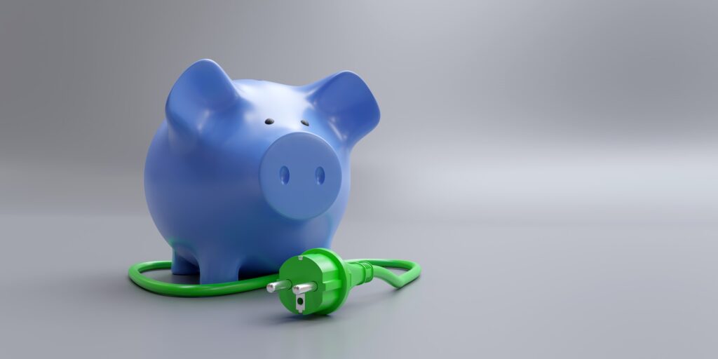 Green power plug and piggy bank. House electricity cost saving.