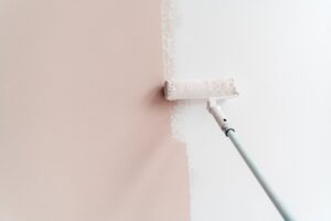 Painting house interior wall with roller into white. Apartment renovation, redecoration and repair