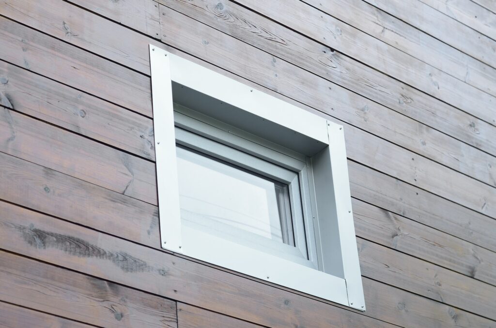 Plastic PVC window in modern passive wooden house facade wall