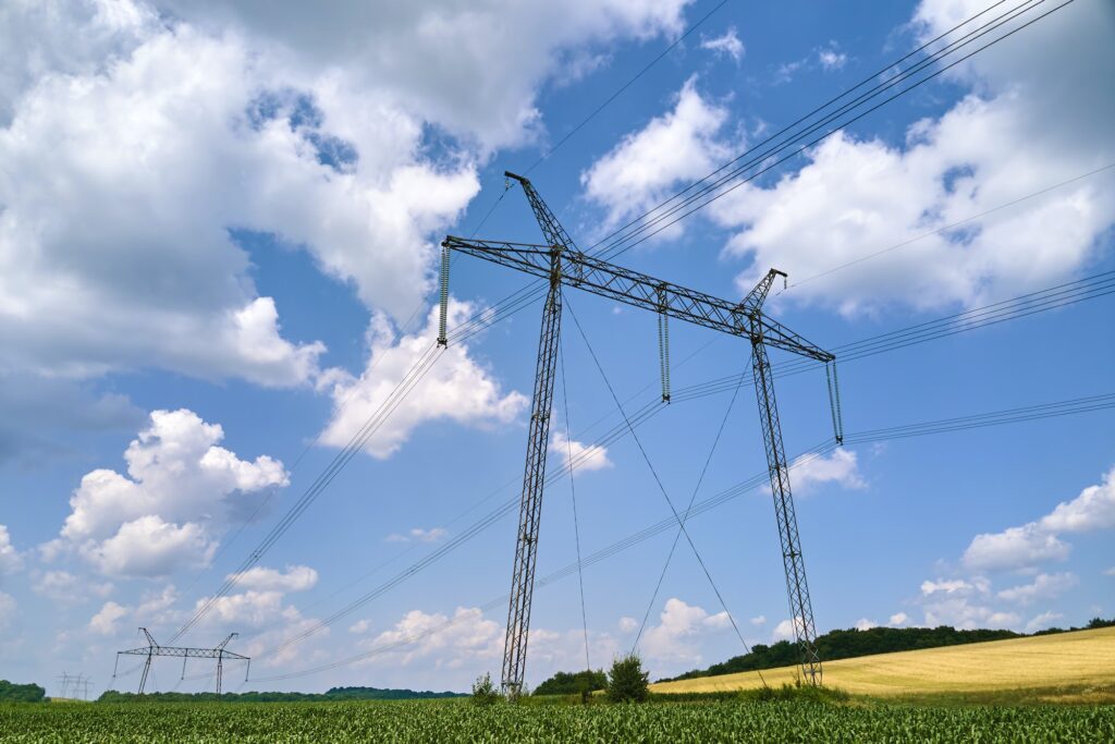 Tower with electric power lines for transfering high voltage electricity located in agricultural