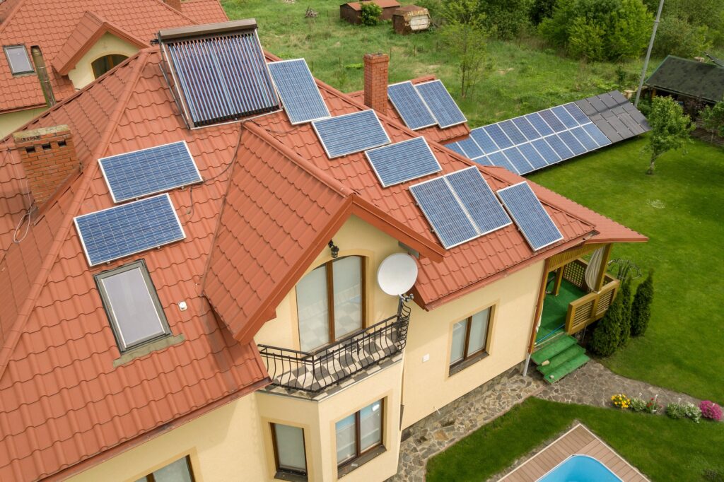 Aerial view of a new autonomous house with solar panels and water heating radiators on the roof