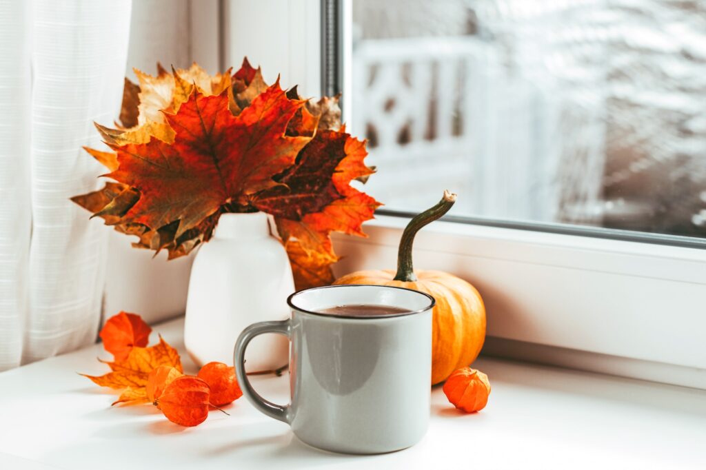 Autumn still life on the window of dry leaves and pumpkin