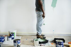 Black man painting house wall