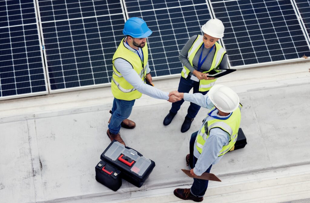 Handshake, engineering and team working on solar panels for inspection, maintenance or installation