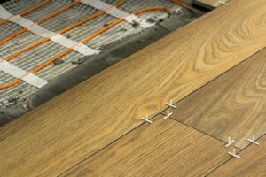 Installation of ceramic tiles and heating elements in warm tile floor. Renovation and improvement