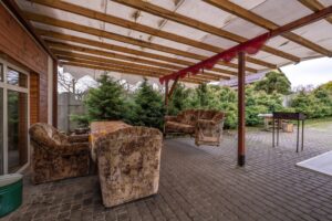 interior of hall veranda or gazebo in wooden village vacation home with garden chairs