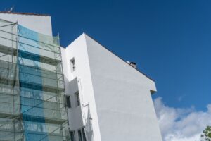 Painted facade of a building with metallic scaffolding wall