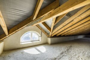 Attic of a building with wooden beams of a roof structure and a small window