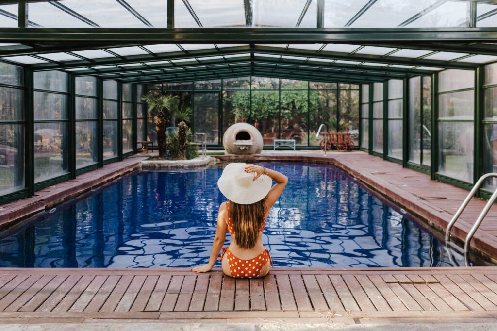 beautiful young woman relaxing in an indoor swimming pool. Summer time and lifestyle