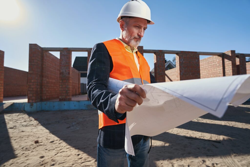 Certified engineer studying the whiteprints of a building