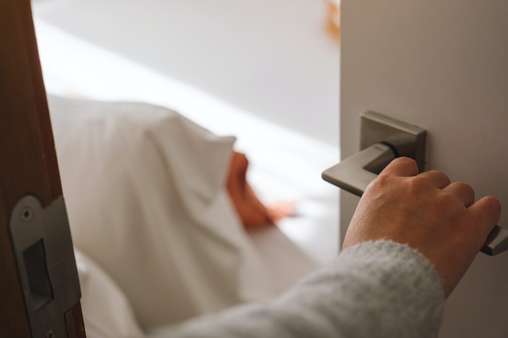 Closeup image of a hand opening bedroom door