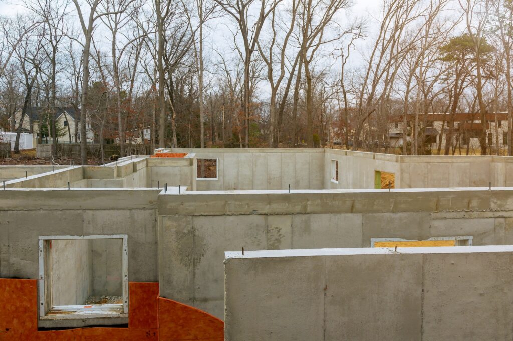 Concrete foundation with waterproofing foam insulation for house under construction fresh concrete