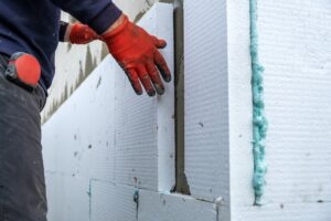 Construction worker installing styrofoam insulation sheets