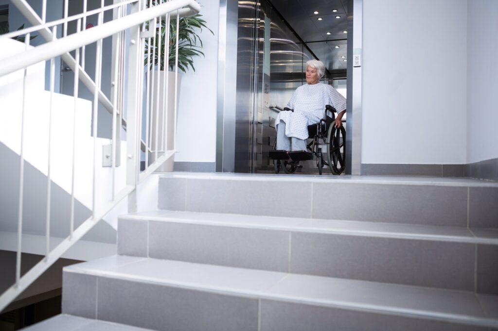 Disabled senior patient on wheelchair in lift
