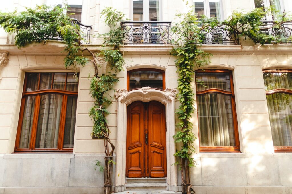 entrance with wooden doors to the beautiful building with green plants in Antwerp, Belgium