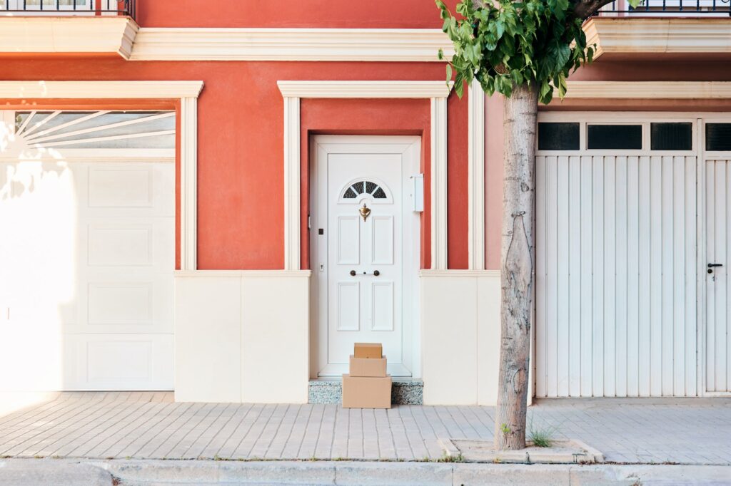 Facade of an orange-colored house with carton boxes on the door