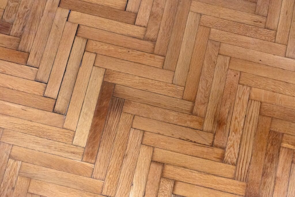 Herringbone pattern parquet wood floor texture. Wooden oak flooring background, overhead