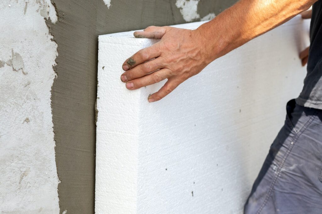 Insulation of facade wall with styrofoam sheets. Polystyrene insulation boards with glue adhesive