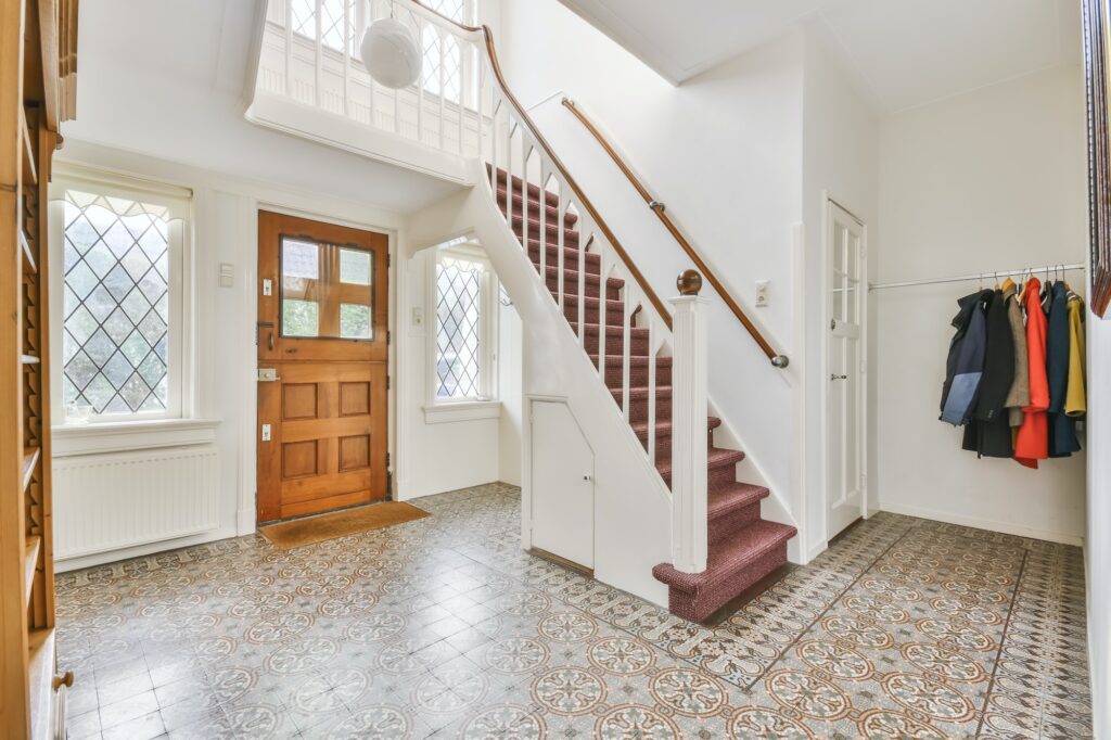 Large entrance hall with a wooden door and stairs