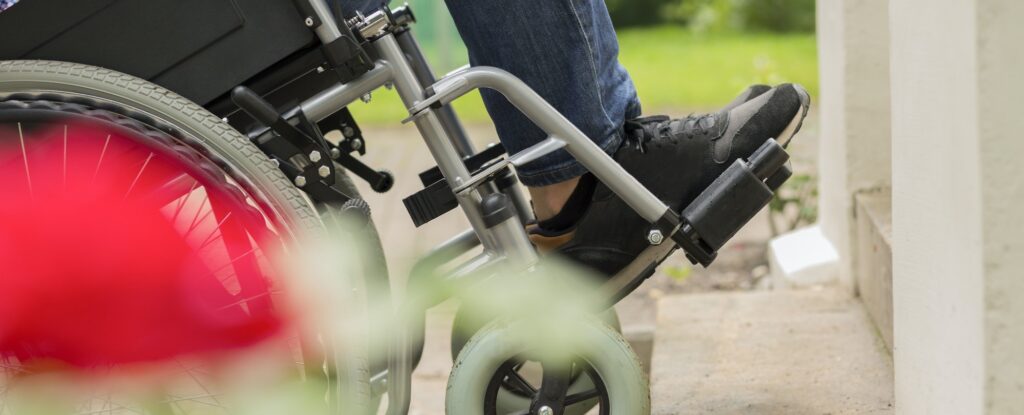 Man on a wheelchair trying to overcome the stairs