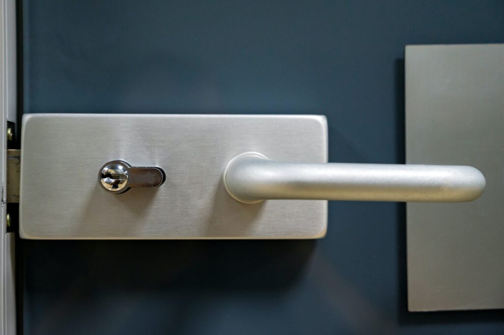 Metal door handle and lock on grey door with lock