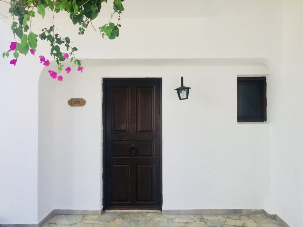 Minimalistic view of a house entrance with wooden door in Greece