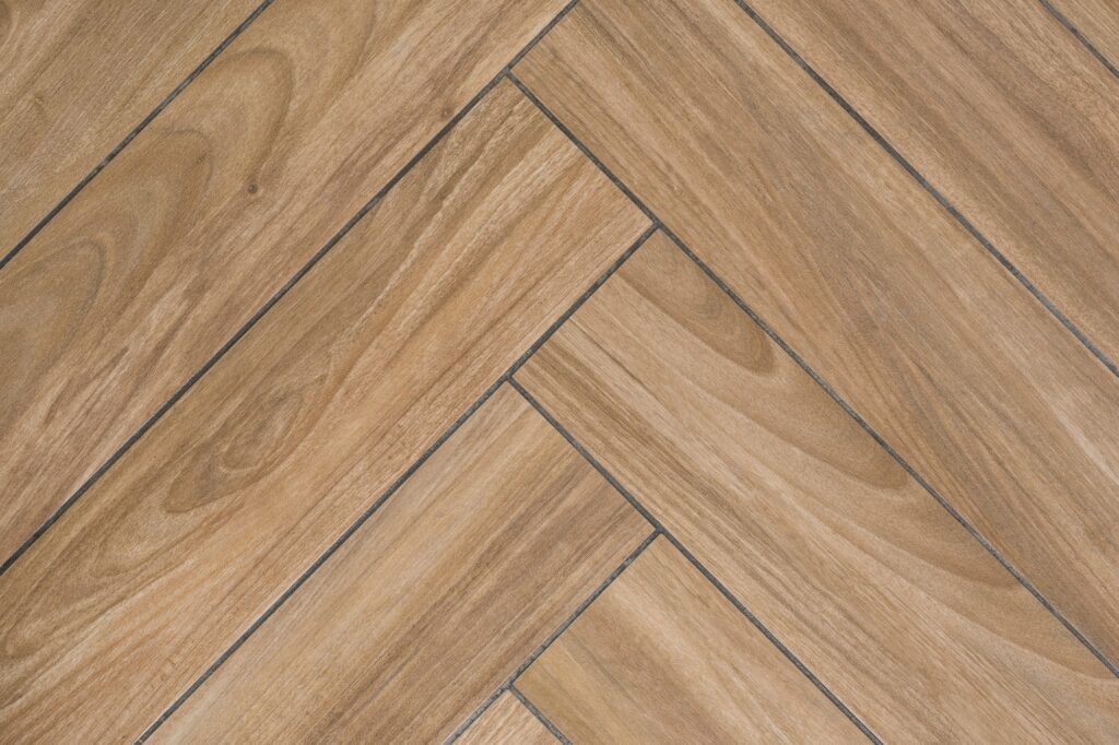 Oak wood texture of floor with tiles immitating hardwood flooring. Traditional herringbone pattern