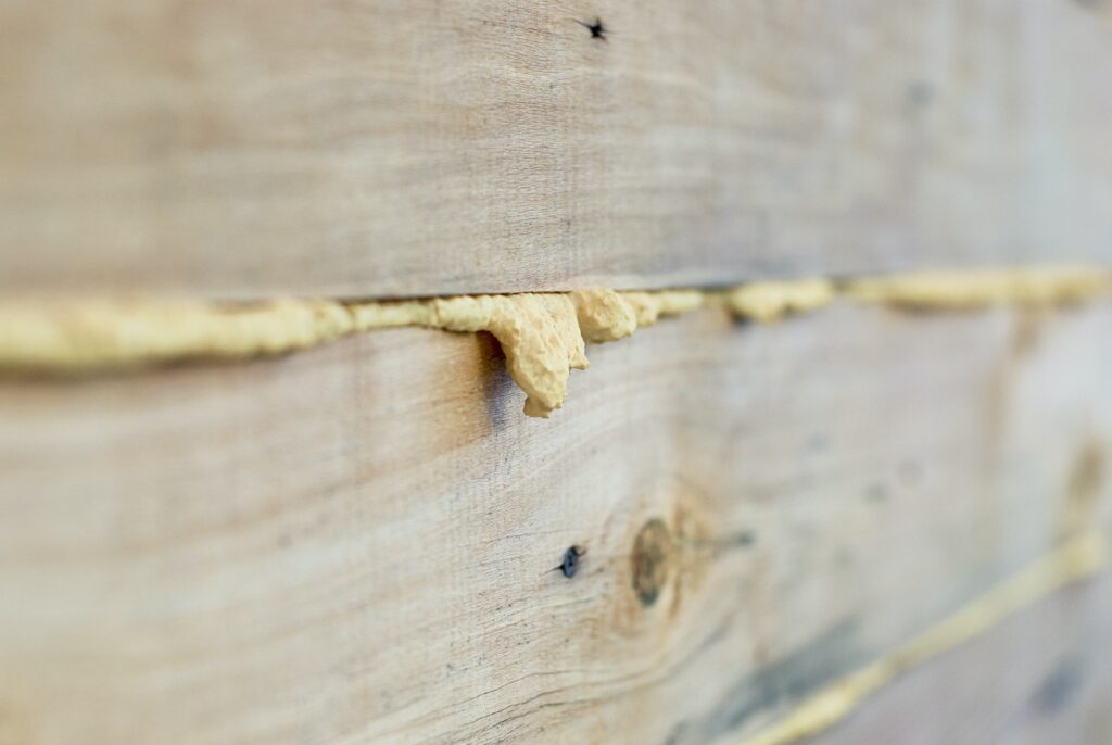 Seams of wooden house wall filled with polyurethane foam