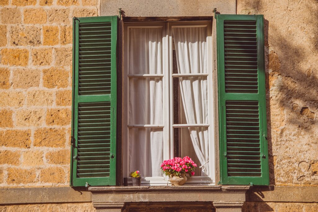 window with flowers on windowsill in Orvieto, Rome suburb, Italy