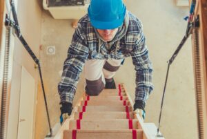 Worker Climbing on Attic Stairs