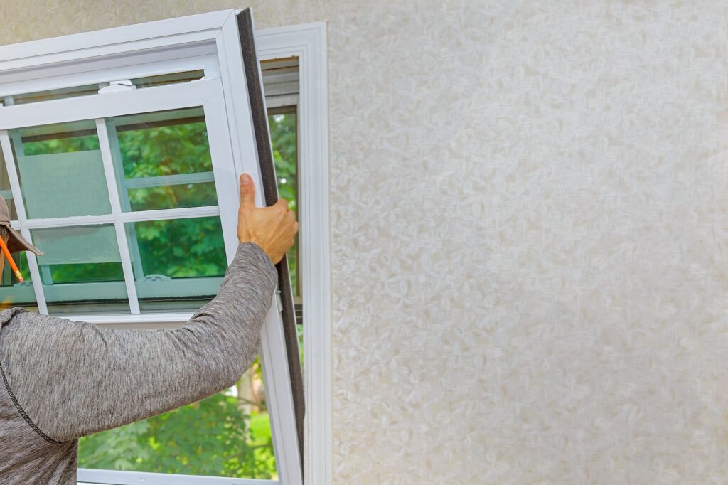 Worker in the installing new, windows in an house, with a new window in the home renovation living